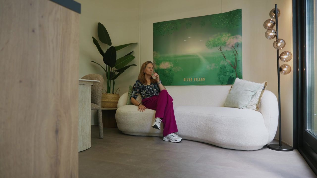 Op de bank met een boek, de tuin door het grote raam