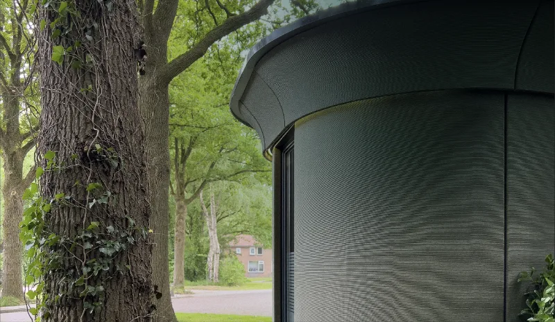 Qbuzz Oosterwolde pauzelocatie met gebogen Silco7-gevel naast een eik